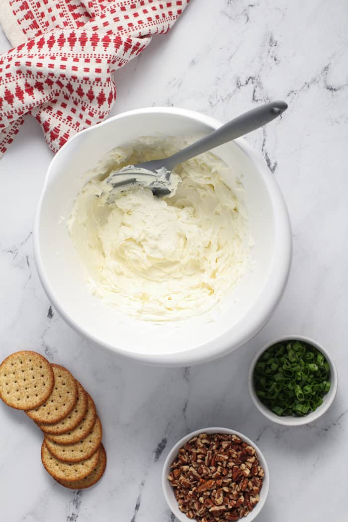 Cream cheese and goat cheese mixed together in a white mixing bowl