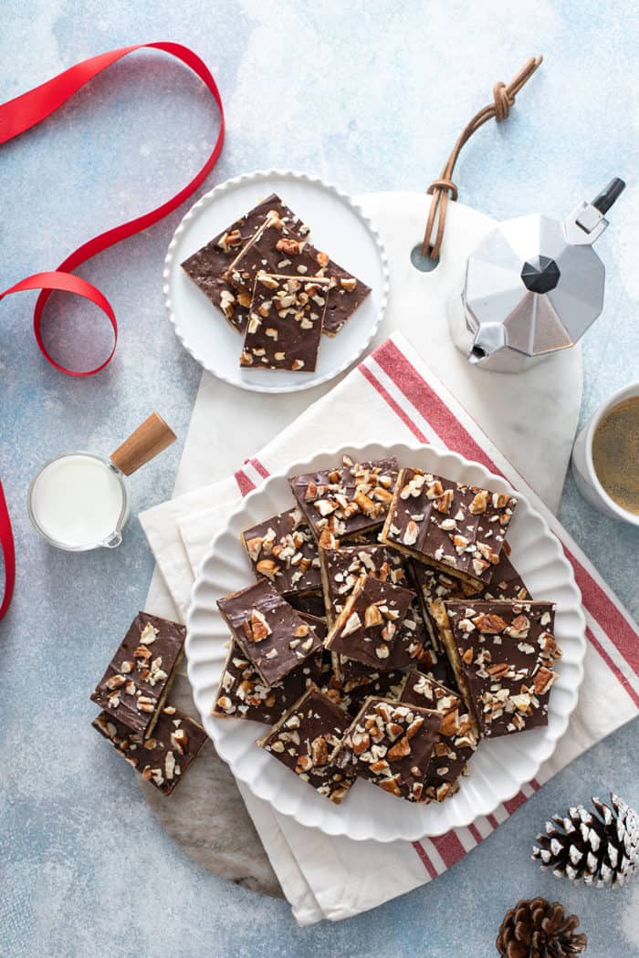 Overhead view of plates full of saltine toffee next to coffee and an espresso maker