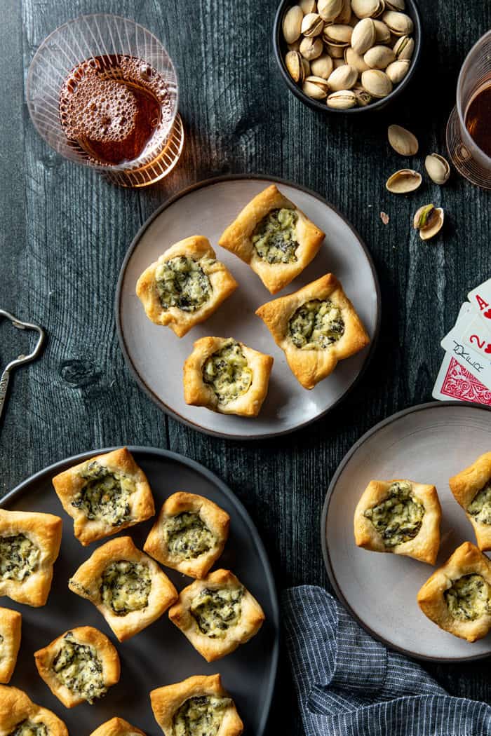 Spinach artichoke bites arranged on a variety of plates