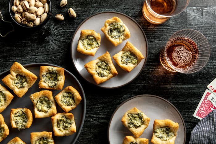 Plates filled with spinach artichoke bites arranged on a table