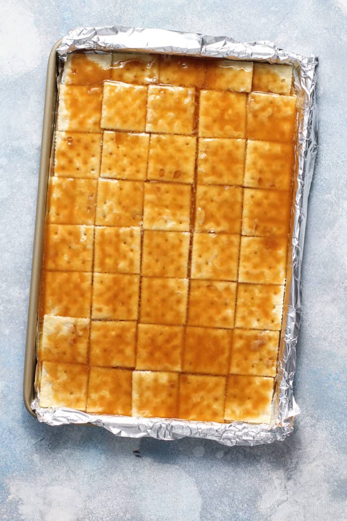 Saltine crackers and toffee candy base in a foil lined sheet pan