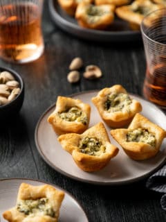 Close up of four spinach artichoke bites on a white plate