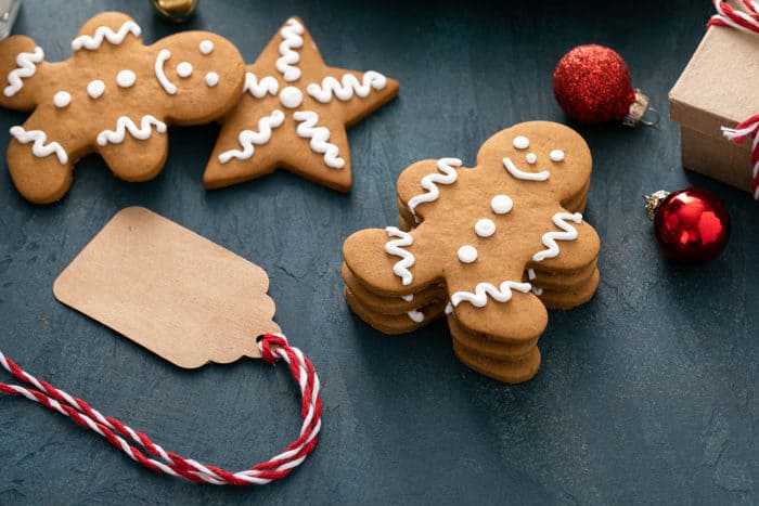 Stack of gingerbread man cutout cookies next to a gift tag