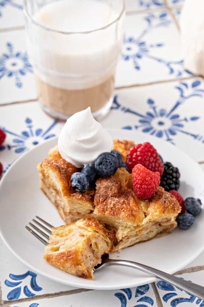 Fork cutting a bite off a slice of croissant bread pudding