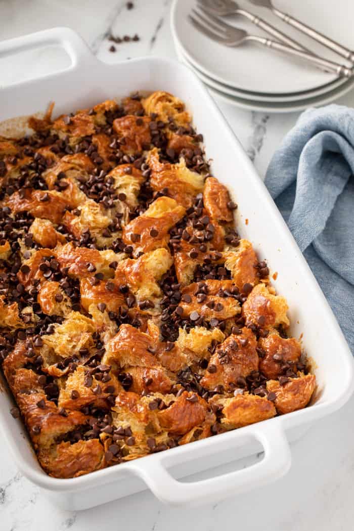 Chocolate chip bread pudding in a white baking dish, fresh out of the oven