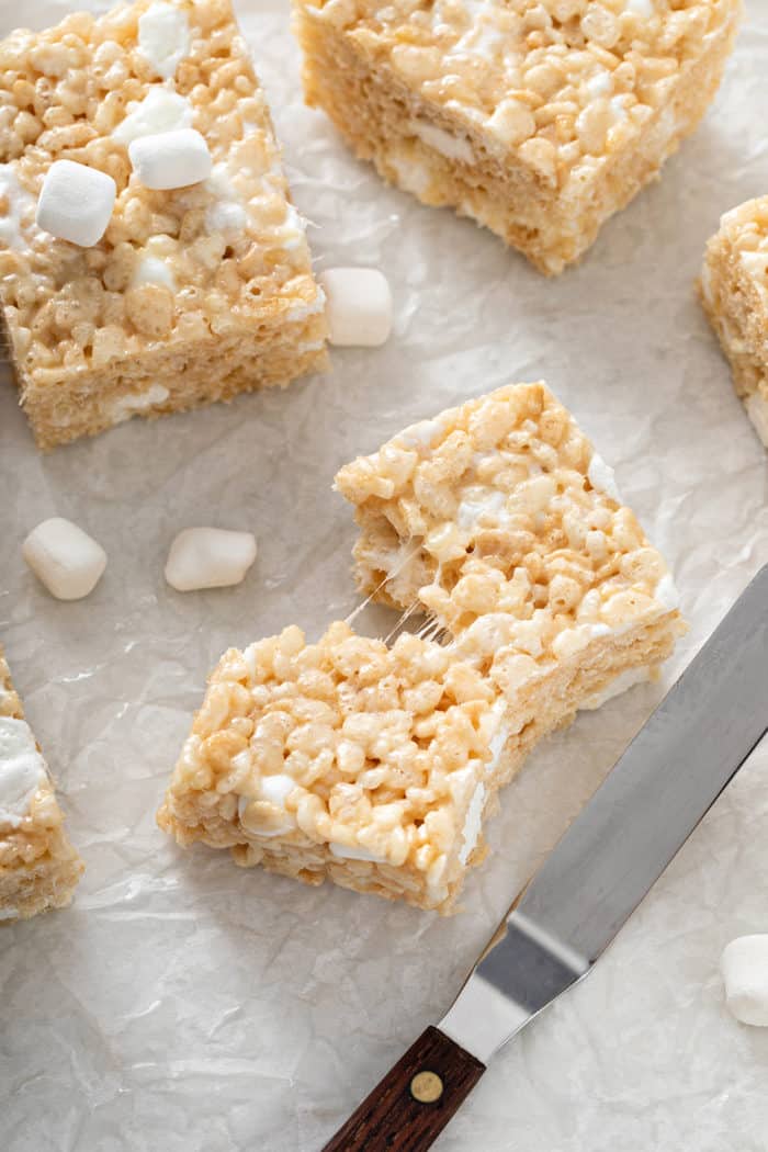 Rice krispie treat pulled apart into two set on a piece of parchment paper