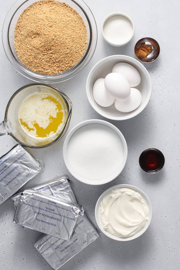 Ingredients for cheesecake bars arranged on a white countertop