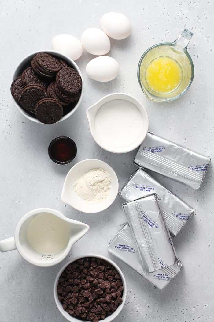 Ingredients for chocolate cheesecake arranged on a marble countertop