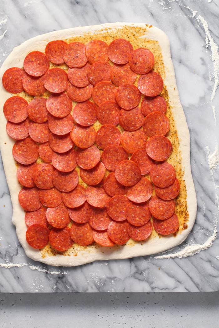 Rolled bread dough topped with slices of pepperoni