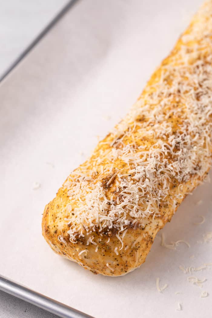 Loaf of pepperoni bread on a parchment-lined baking sheet, ready to be baked