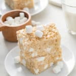 Two classic rice krispie treats stacked on a white plate