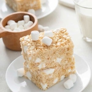Two classic rice krispie treats stacked on a white plate