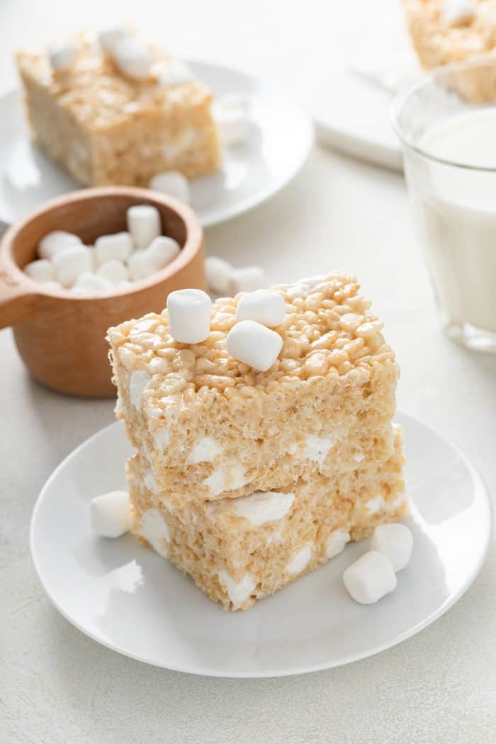 Two classic rice krispie treats stacked on a white plate