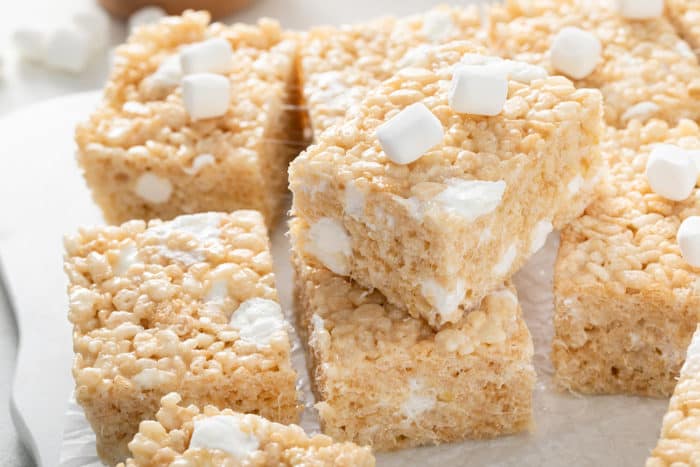Classic rice krispie treats stacked on a piece of parchment paper