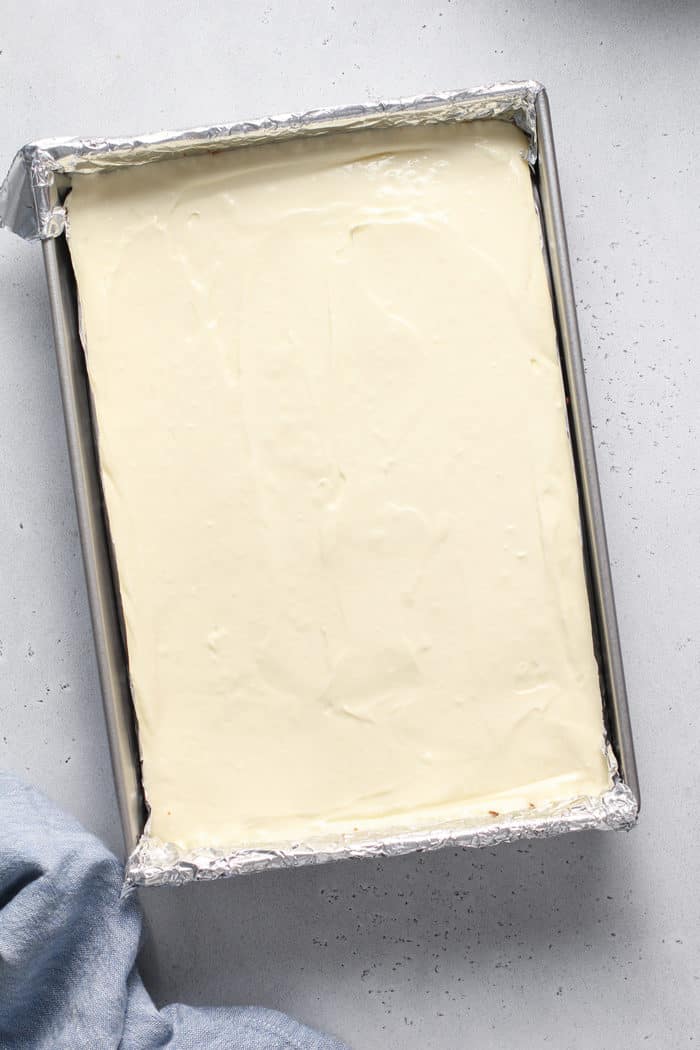 Unbaked cheesecake bars in a foil-lined 13x9-inch pan