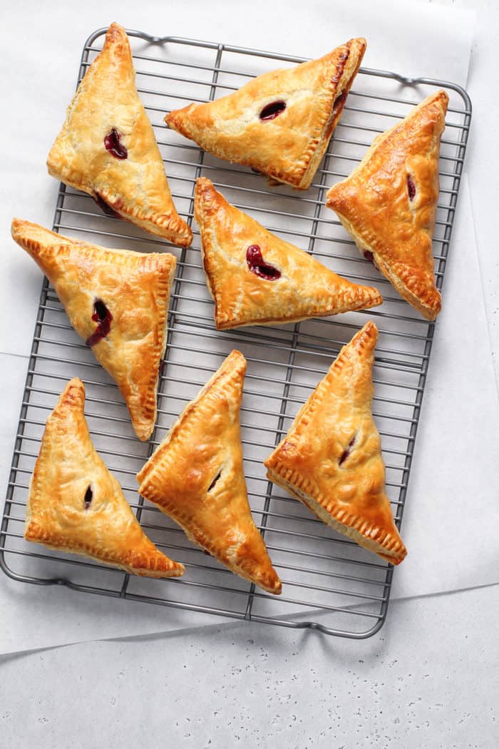 Freshly baked cherry turnovers cooling on a wire rack