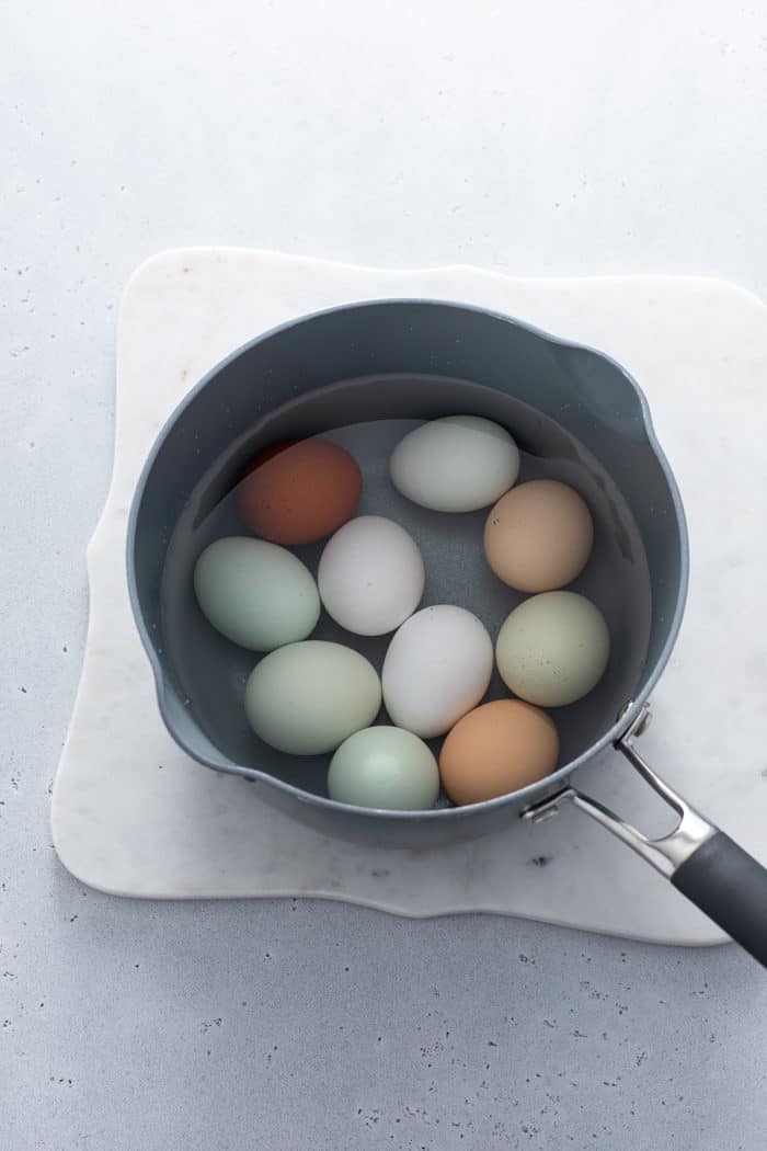 Whole eggs in a sauce pot filled with water