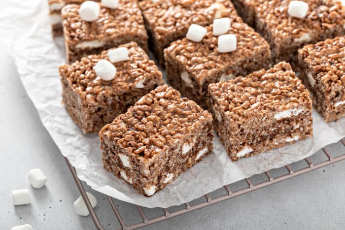 Hand pulling apart a chocolate rice krispie treat to show the soft, gooey middle
