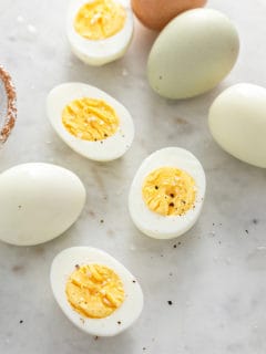 Close up of several hard boiled egg halves on a marble surface