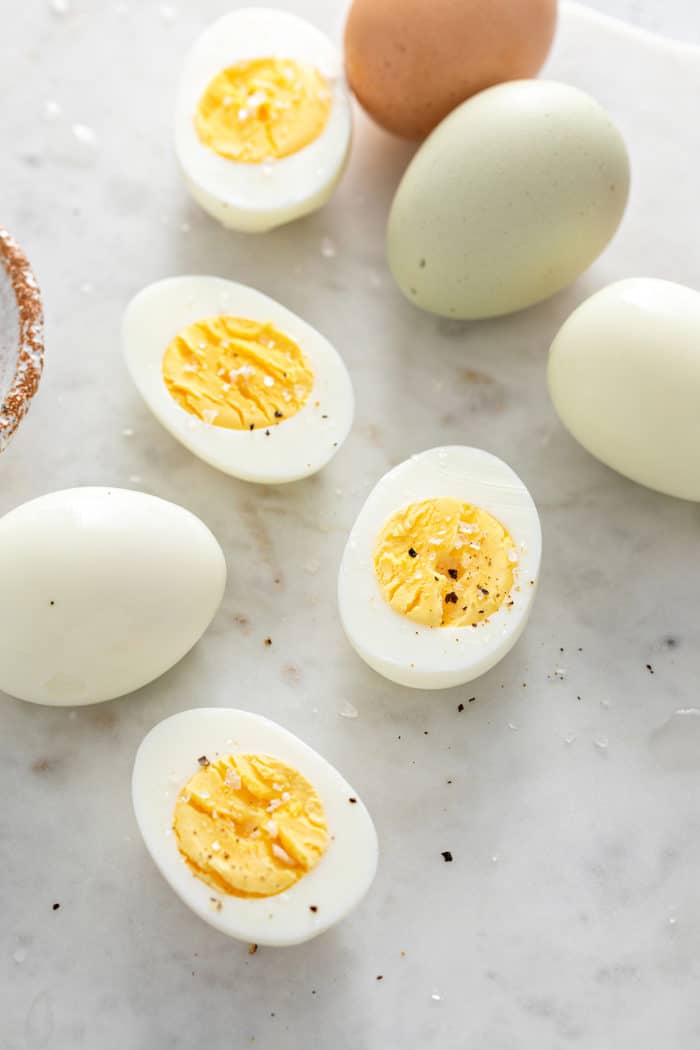 Close up of several hard boiled egg halves on a marble surface