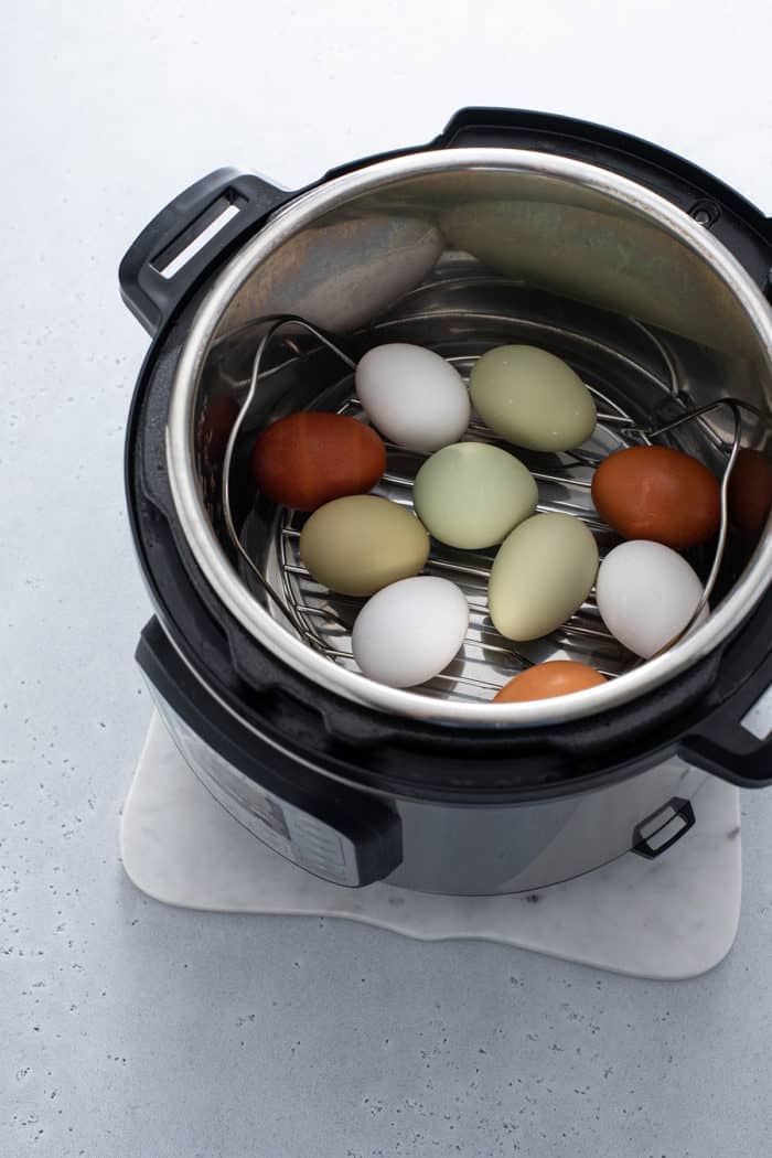 Whole eggs set on a rack inside of an instant pot