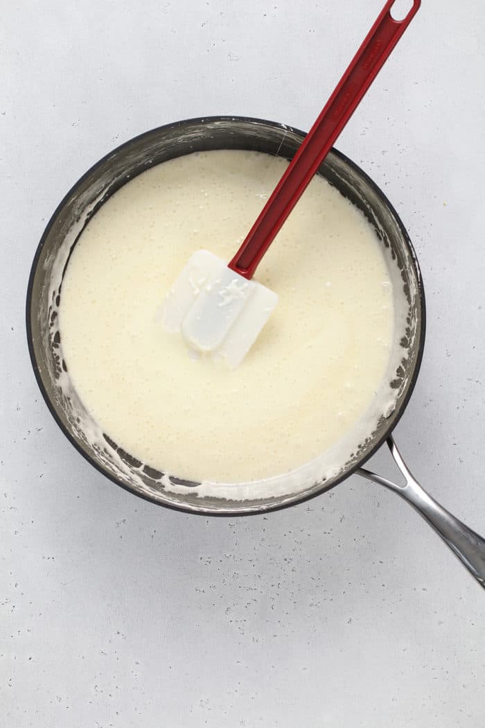 Spatula stirring melted marshmallows in a saucepan