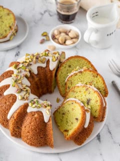Sliced pistachio pudding cake on a white platter