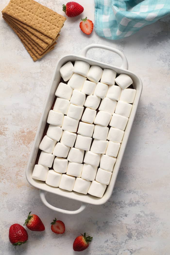 Assembled s'mores dip in a white baking dish, ready to bake