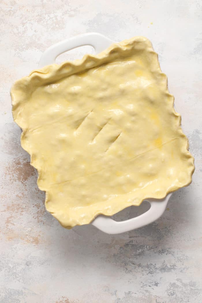 Assembled chicken pot pie casserole in a white baking dish, ready to go in the oven