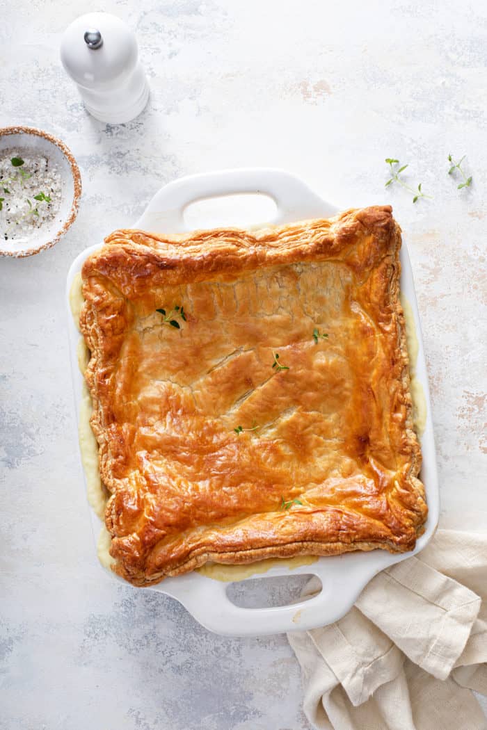 Overhead view of baked chicken pot pie casserole in a white baking dish