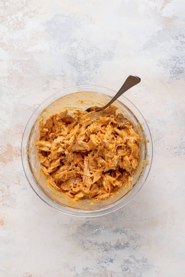 Buffalo chicken mixture for sliders in a glass mixing bowl