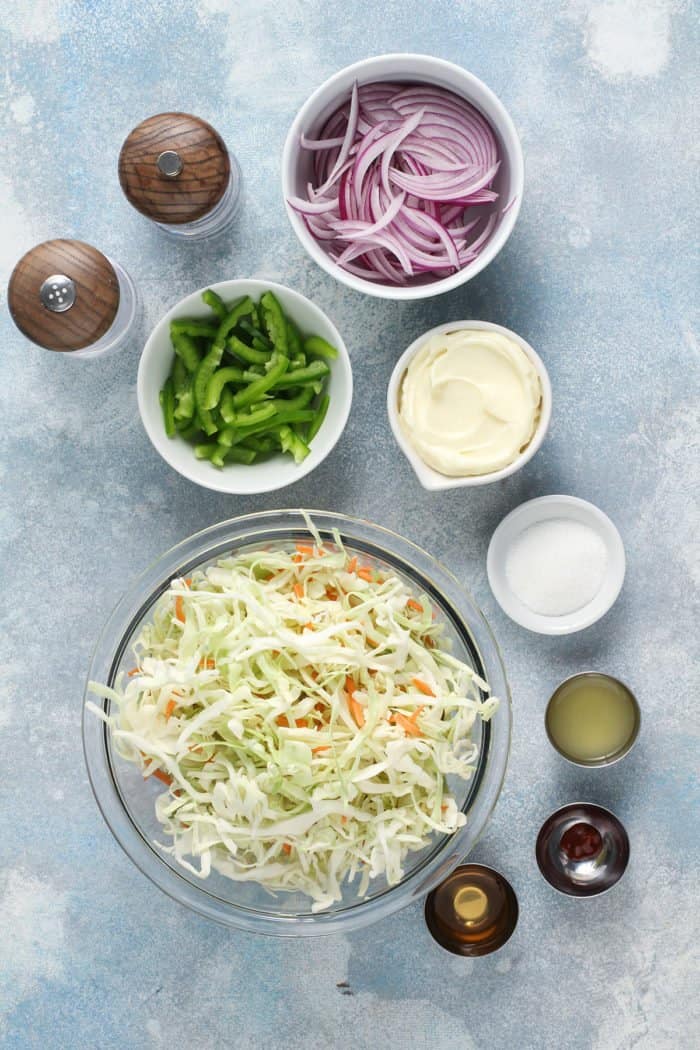 Easy coleslaw ingredients arranged on a blue countertop