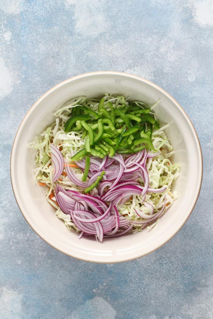 Vegetables for coleslaw in a white mixing bowl