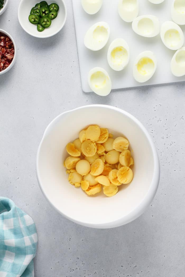 Hard boiled egg yolks in a white mixing bowl