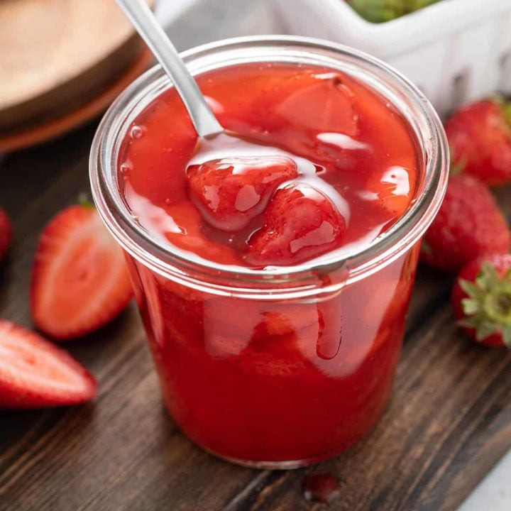 Close up of a glass jar filled with homemade strawberry sauce
