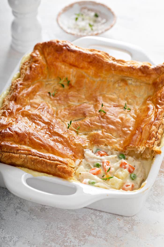 Chicken pot pie casserole in a white baking dish with a corner of the casserole removed