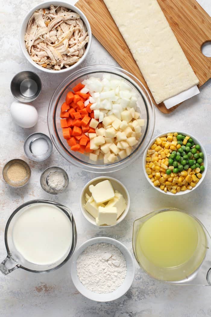 Chicken pot pie casserole ingredients arranged on a gray countertop