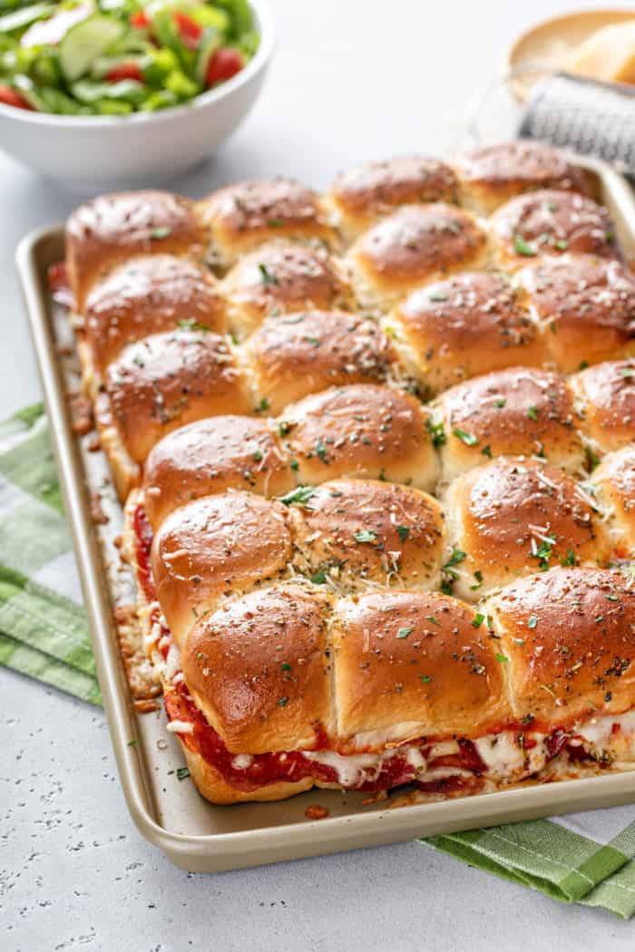 Baked pizza sliders on a rimmed baking sheet.