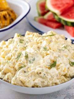 Serving bowl filled with easy potato salad garnished with sprigs of fresh dill.