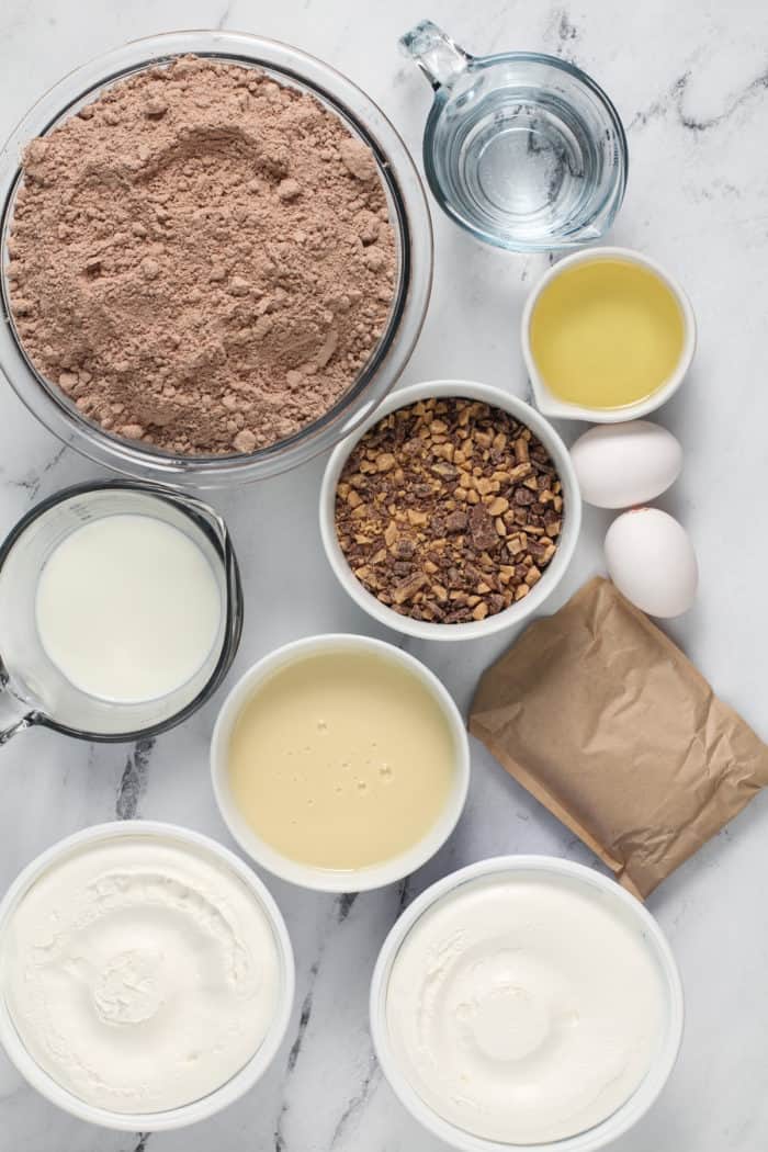 Brownie trifle ingredients arranged on a marble countertop.