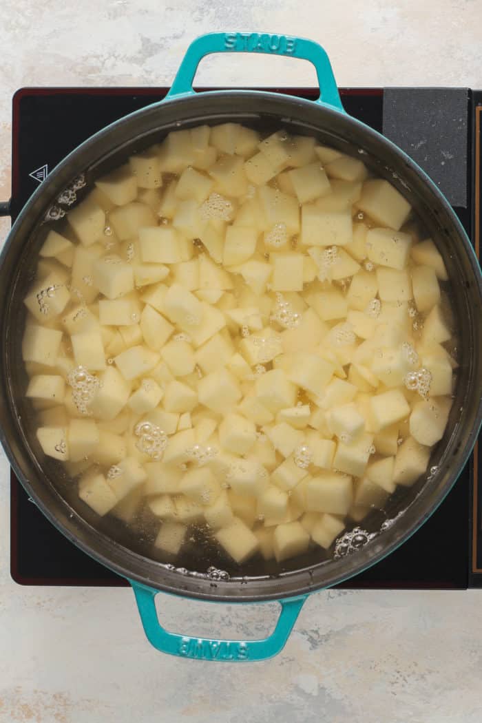 Diced potatoes cooking in a large dutch oven.