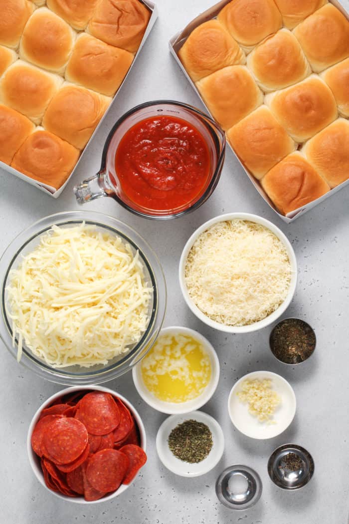 Pepperoni pizza slider ingredients arranged on a gray countertop.