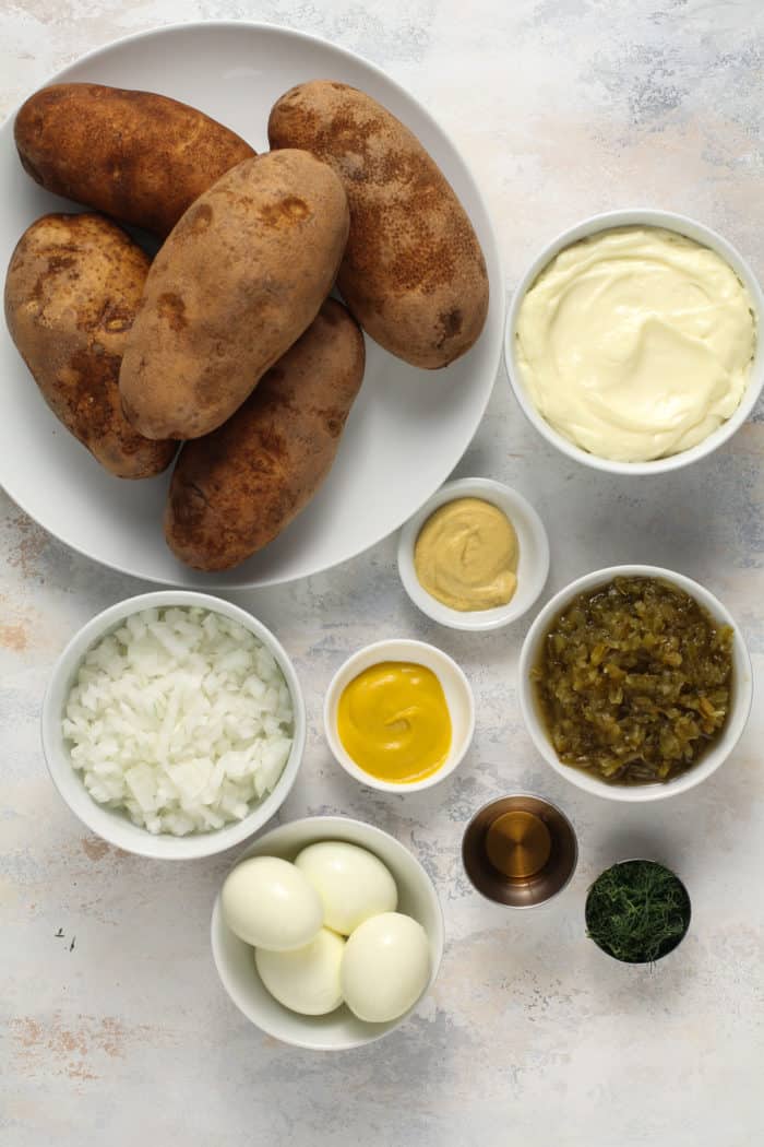 Ingredients for easy potato salad arranged on a light-colored countertop.