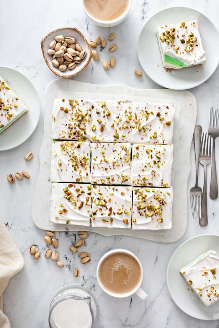 Overhead view of sliced pistachio pudding dessert topped with chopped pistachios, ready to be served.