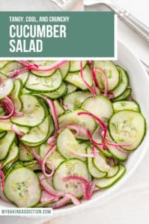 Close up of cucumber salad in a white serving bowl. Text overlay includes recipe name.
