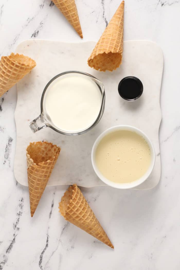 Ingredients for no-churn ice cream arranged on a marble surface.