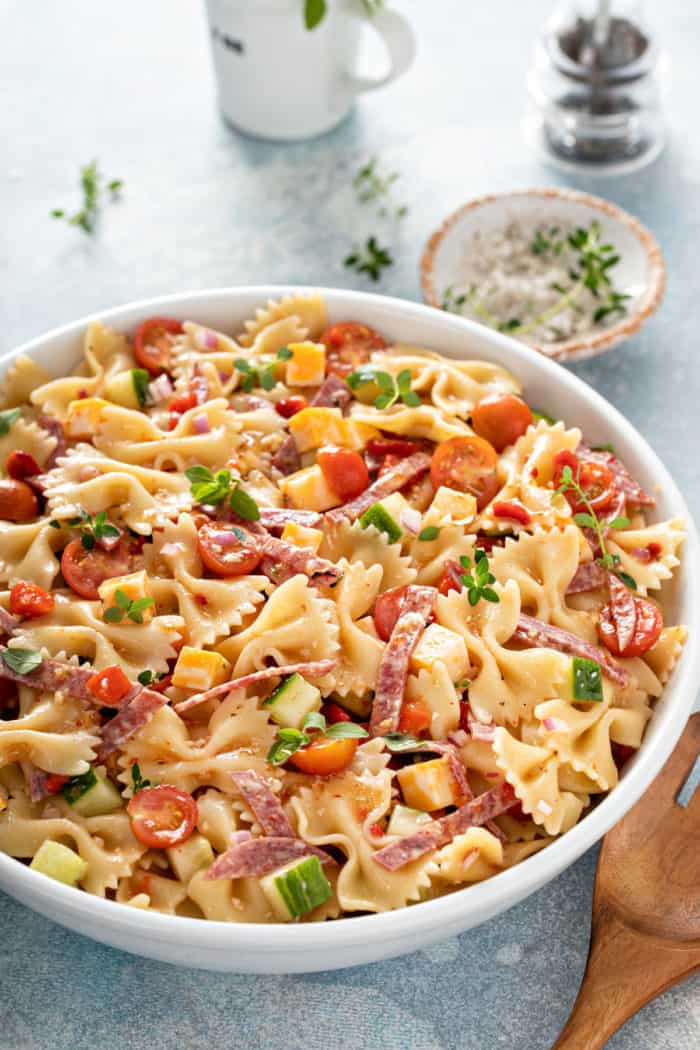 Large white bowl filled with italian pasta salad.