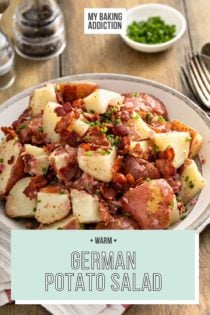 German potato salad, garnished with bacon and chives, in a large serving bowl. Text overlay includes recipe name.