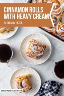 Three white plates with tiktok cinnamon rolls set on a marble countertop next to a baking dish of cinnamon rolls. Text overlay includes recipe name.