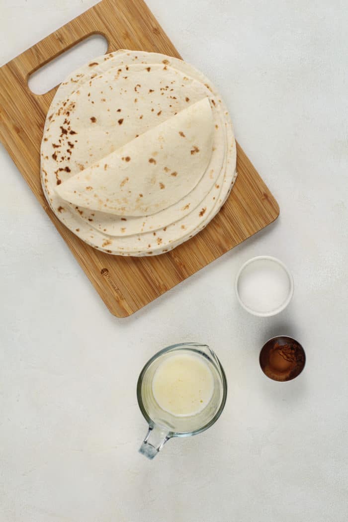 Ingredients for cinnamon tortilla chips arranged on a light-colored countertop.